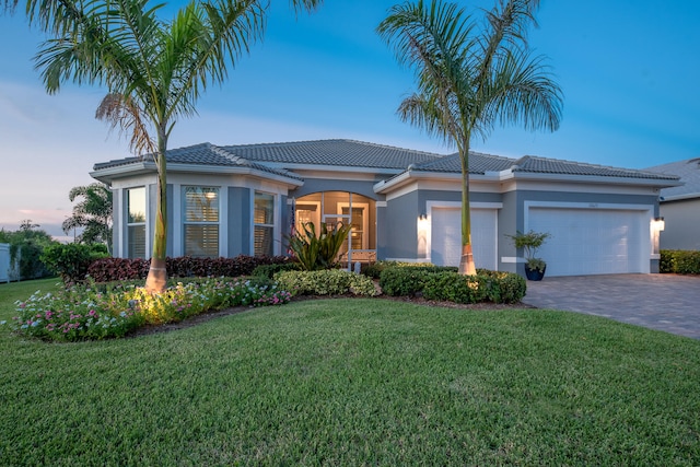 view of front of property featuring a yard and a garage