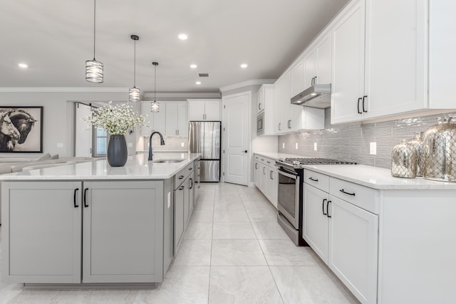 kitchen with a large island, white cabinets, sink, decorative light fixtures, and stainless steel appliances