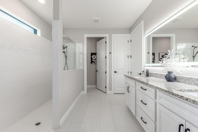 bathroom featuring vanity and tiled shower