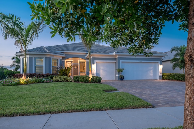 view of front facade featuring a garage and a lawn