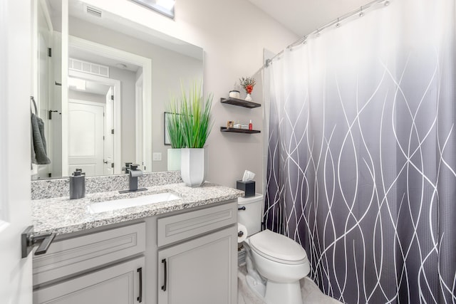 bathroom with vanity, walk in shower, and toilet