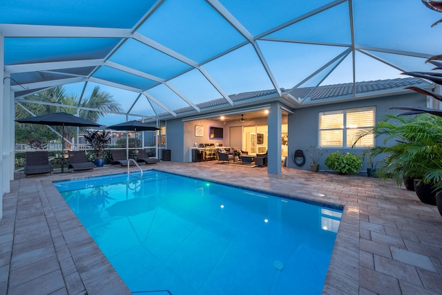 view of pool with a patio, an outdoor hangout area, ceiling fan, and glass enclosure