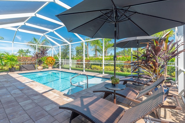 view of swimming pool featuring a patio area and glass enclosure