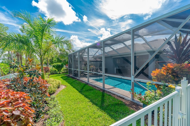 view of pool with a lanai and a lawn