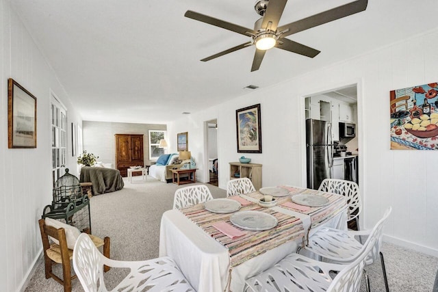 carpeted dining space featuring ceiling fan