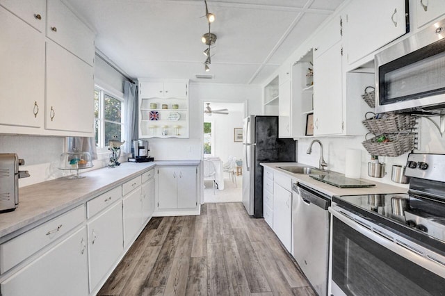 kitchen with ceiling fan, sink, white cabinetry, light wood-type flooring, and stainless steel appliances