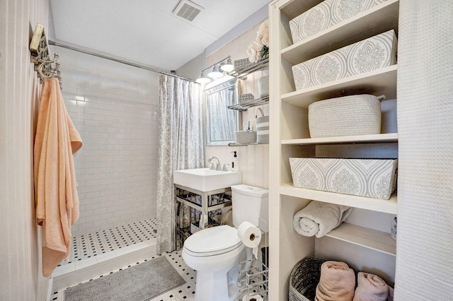 bathroom with toilet, sink, and curtained shower