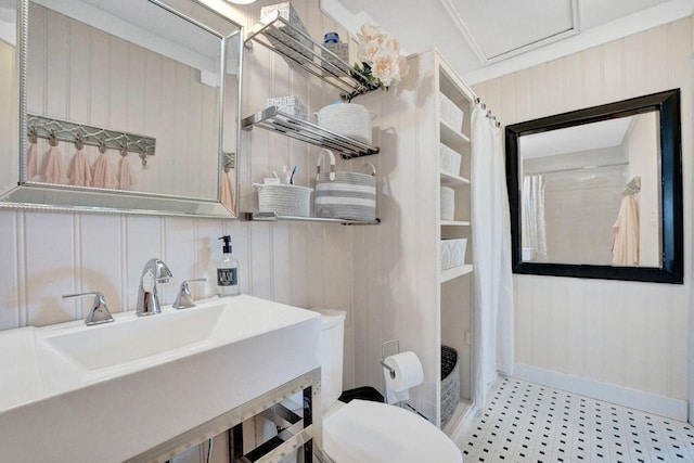 bathroom featuring toilet, sink, and curtained shower