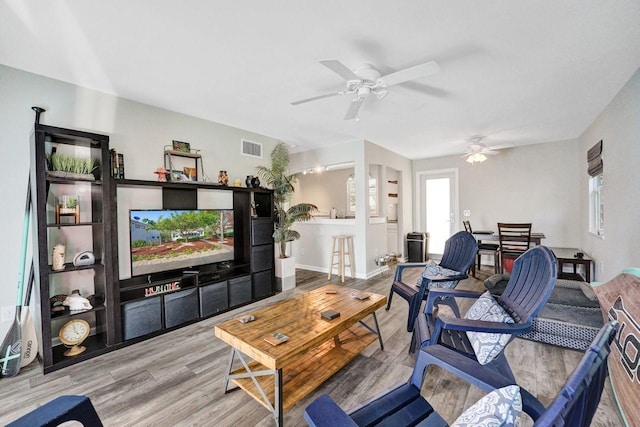 living area featuring visible vents, wood finished floors, a ceiling fan, and plenty of natural light
