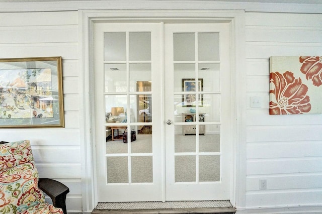 doorway to outside with wood walls and french doors