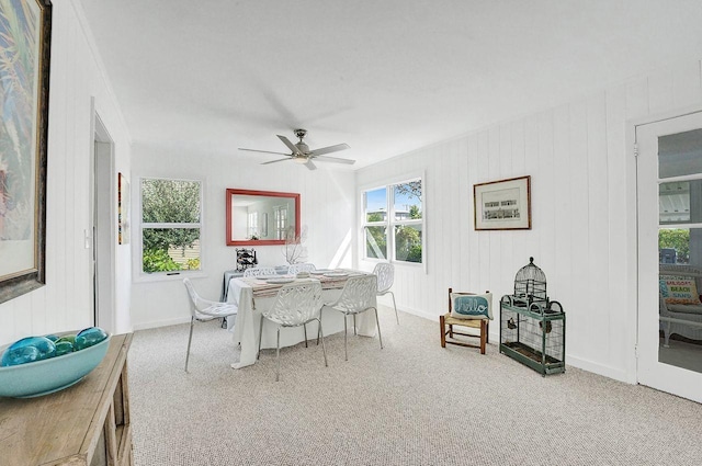 dining space featuring ceiling fan and light colored carpet