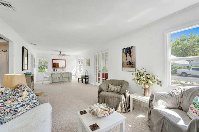 carpeted living room featuring ceiling fan, a wealth of natural light, and french doors