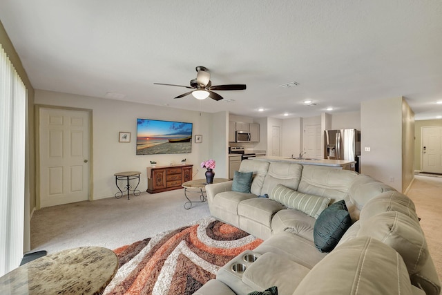 carpeted living room featuring ceiling fan