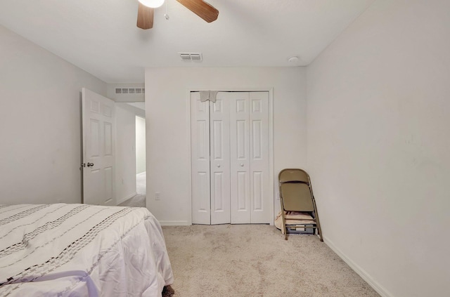 bedroom with a closet, ceiling fan, and light carpet