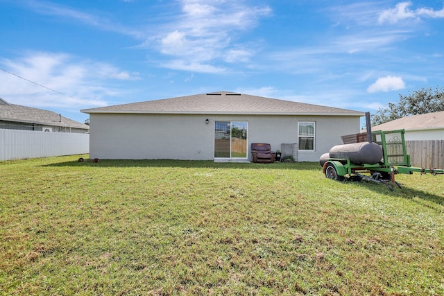 rear view of property featuring a lawn