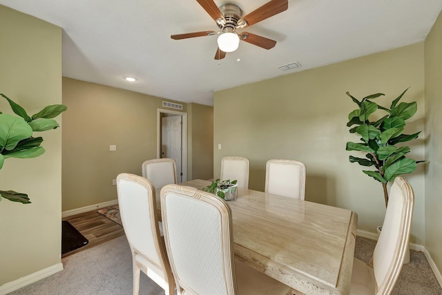 dining space featuring light colored carpet and ceiling fan