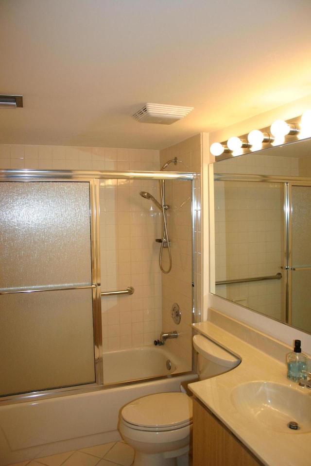 full bathroom featuring toilet, tile patterned floors, bath / shower combo with glass door, and vanity