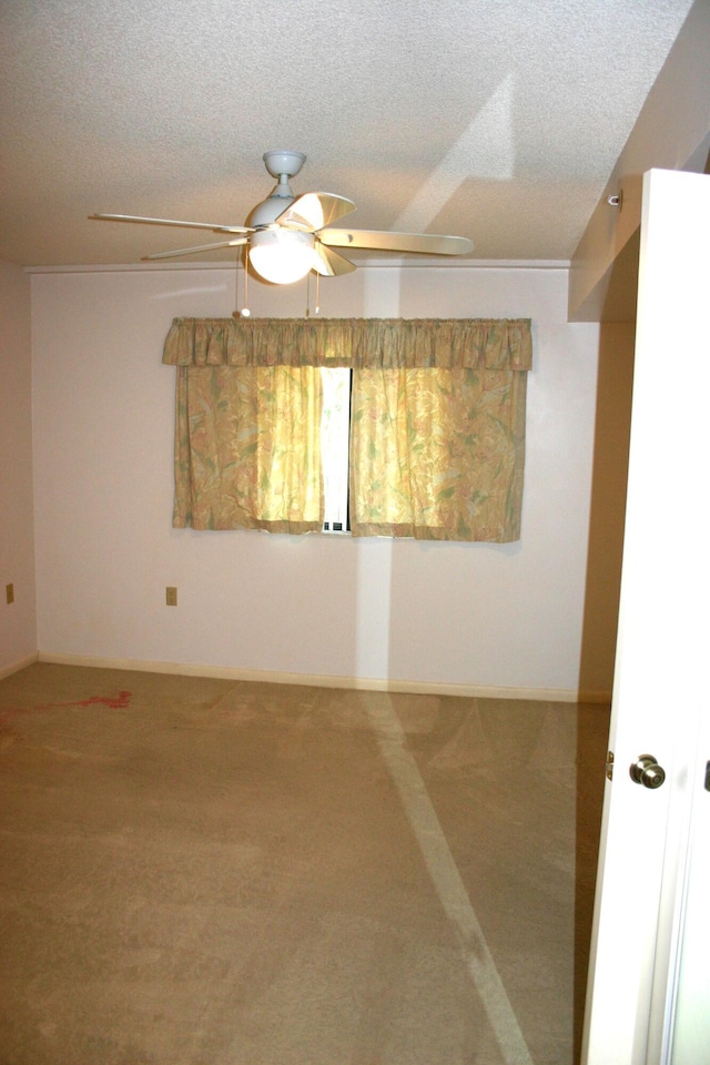 spare room featuring ceiling fan, carpet flooring, and a textured ceiling