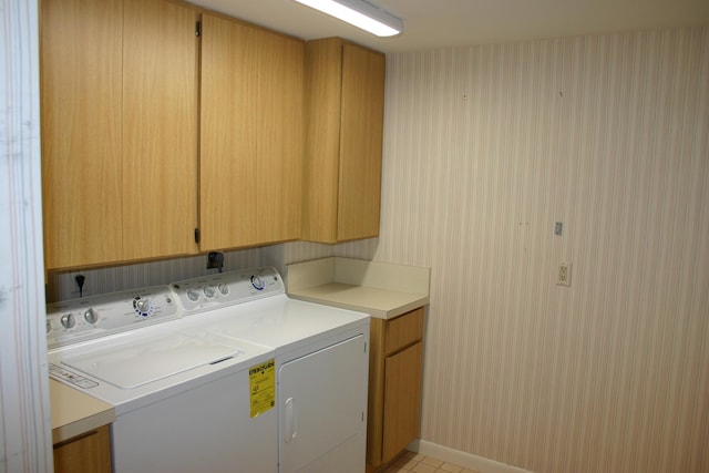 laundry area with separate washer and dryer and cabinets