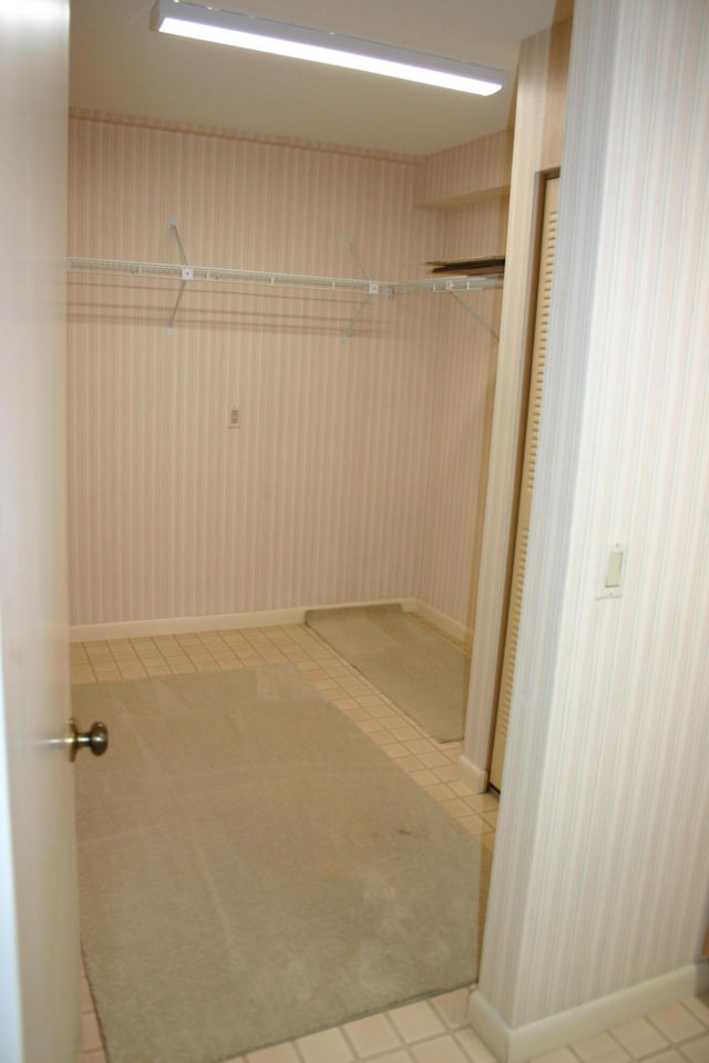 walk in closet with light tile patterned floors