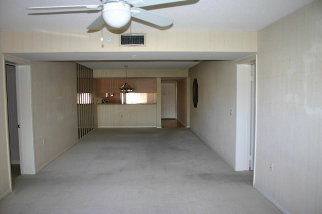 unfurnished living room featuring light colored carpet and ceiling fan