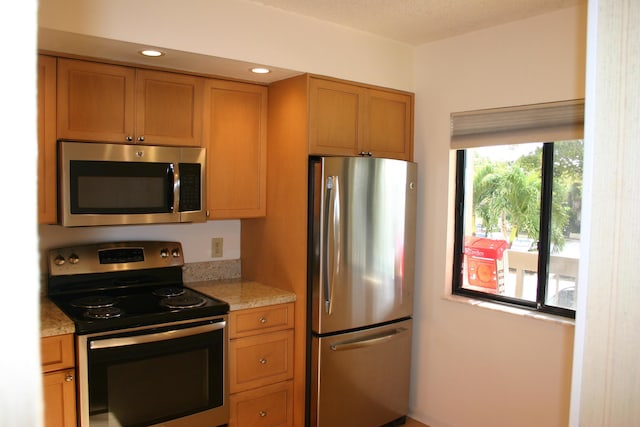 kitchen featuring light stone countertops and appliances with stainless steel finishes