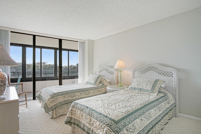 bedroom featuring carpet flooring, a textured ceiling, and expansive windows