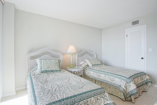 bedroom featuring a textured ceiling and carpet