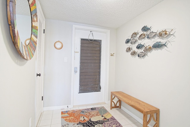 entrance foyer featuring a textured ceiling and light tile patterned floors