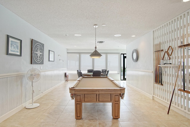 game room featuring light tile patterned flooring, pool table, and a textured ceiling