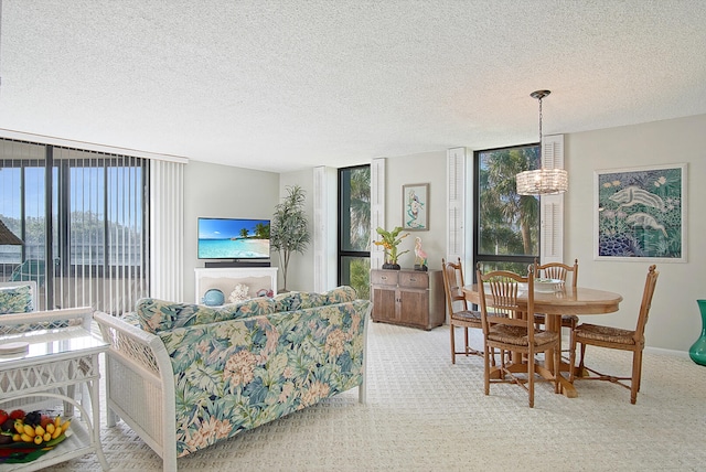 carpeted living room featuring a textured ceiling, a chandelier, and plenty of natural light