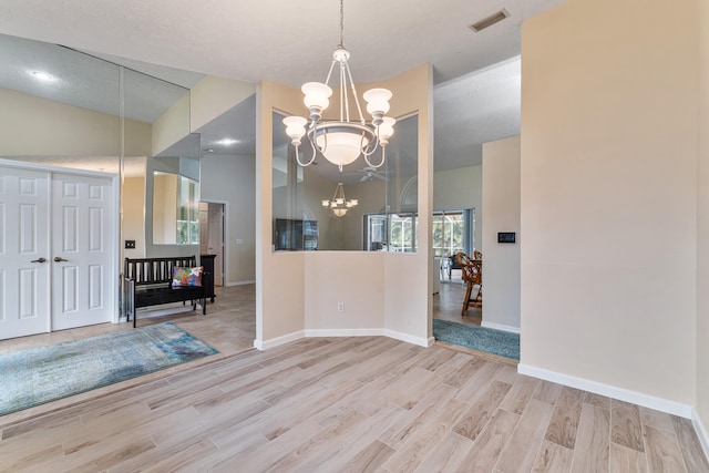 dining room with light wood-type flooring, vaulted ceiling, and a chandelier