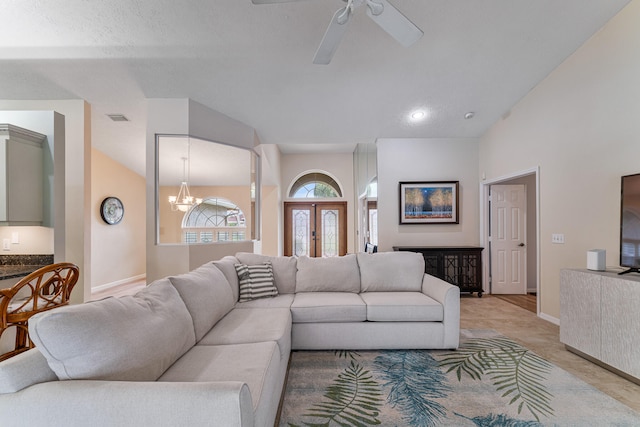 living room with vaulted ceiling, a textured ceiling, and ceiling fan with notable chandelier