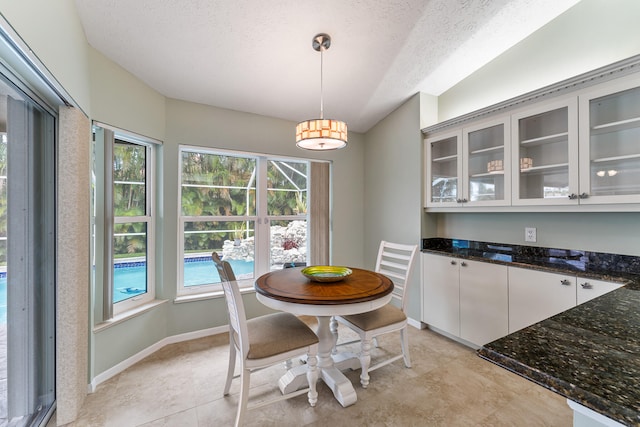 tiled dining area with a textured ceiling