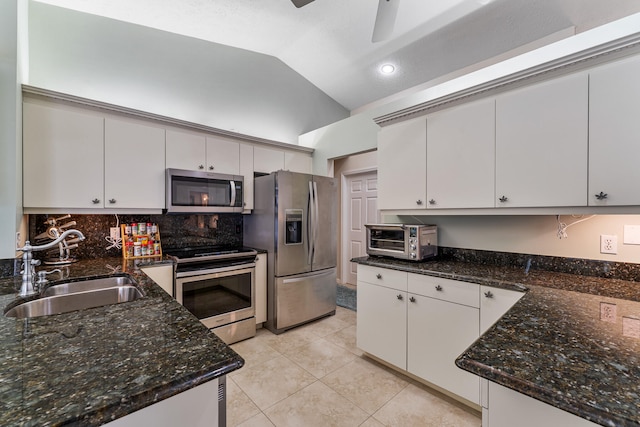 kitchen featuring white cabinetry, stainless steel appliances, sink, and vaulted ceiling