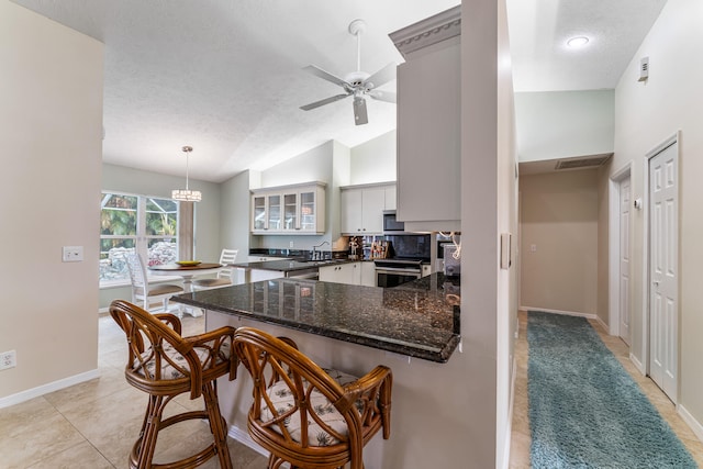 kitchen featuring a kitchen breakfast bar, hanging light fixtures, kitchen peninsula, white cabinets, and a textured ceiling