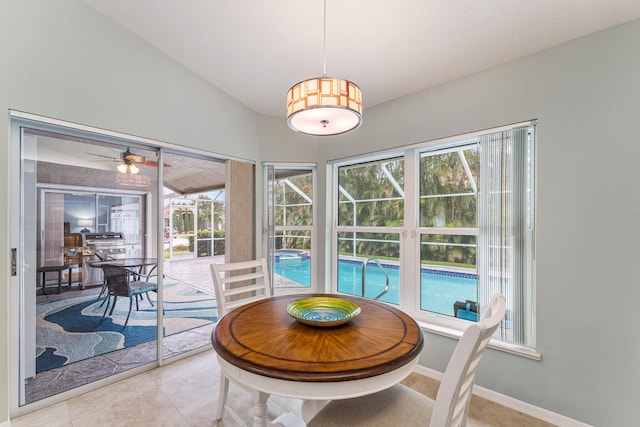 tiled dining space featuring a healthy amount of sunlight and ceiling fan