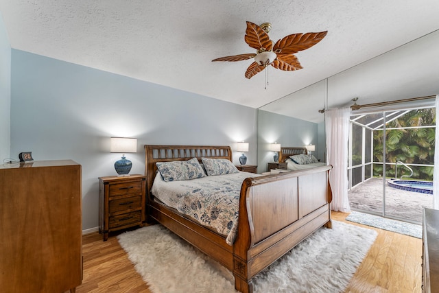 bedroom with ceiling fan, a textured ceiling, light wood-type flooring, and access to exterior