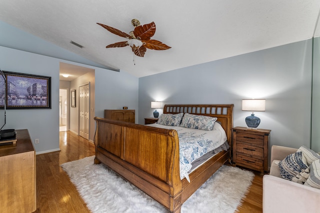 bedroom with dark hardwood / wood-style floors, a closet, ensuite bath, vaulted ceiling, and ceiling fan