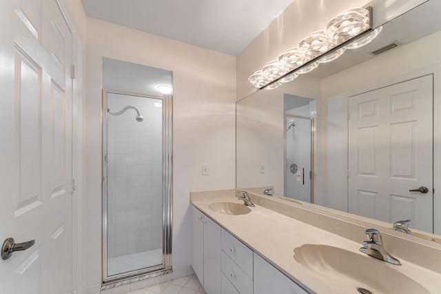 bathroom featuring vanity, a shower with shower door, and tile patterned floors