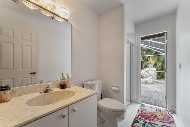 bathroom with a shower with door, vanity, toilet, and tile patterned flooring