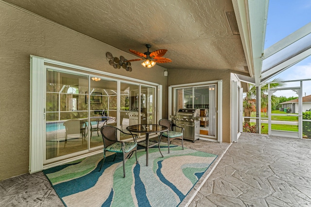 view of patio / terrace featuring grilling area, glass enclosure, and ceiling fan