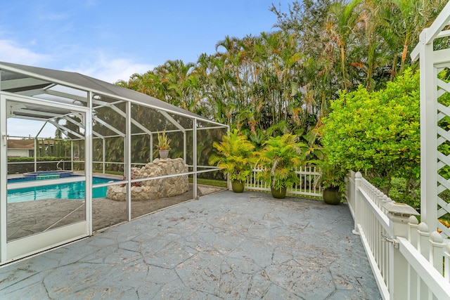 view of patio featuring glass enclosure