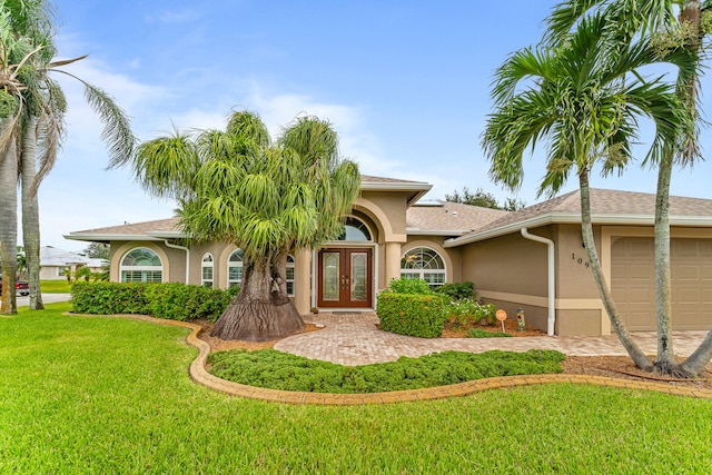 view of front facade featuring french doors, a front yard, and a garage