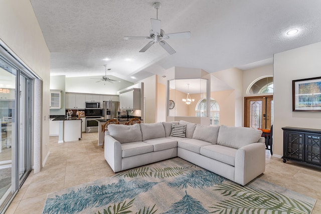 living room with light tile patterned floors, a textured ceiling, lofted ceiling, and ceiling fan with notable chandelier