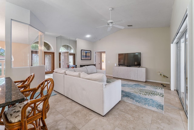 living room with ceiling fan, light tile patterned flooring, and lofted ceiling