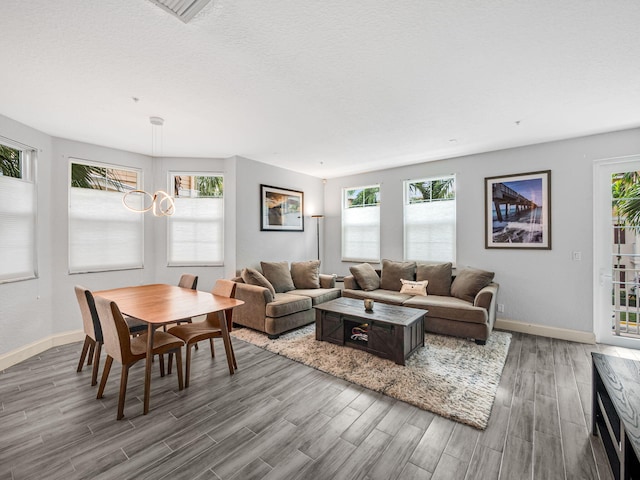 living room with a textured ceiling, wood-type flooring, and a wealth of natural light