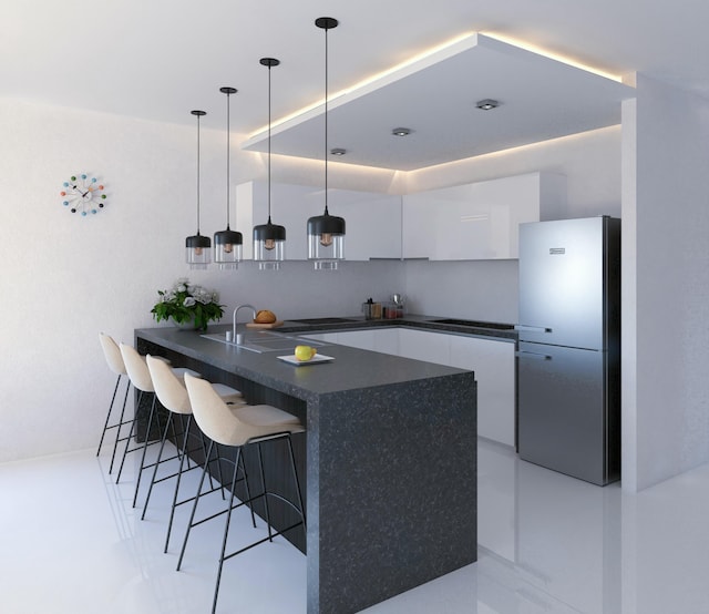 533 NW 16th Ave, Fort Lauderdale, FL 33311 - kitchen featuring dark countertops, a peninsula, freestanding refrigerator, white cabinetry, and modern cabinets