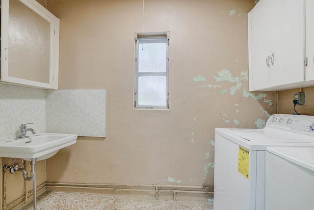 laundry room featuring sink, washer and dryer, and cabinets