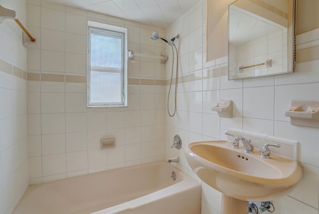 bathroom with tasteful backsplash, tile walls, sink, and tiled shower / bath